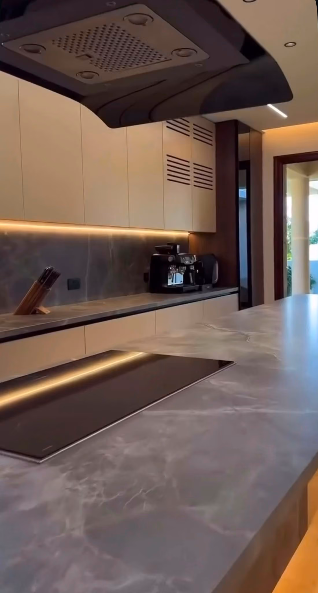 Cocina en madera oscura con isla en mármol azulado